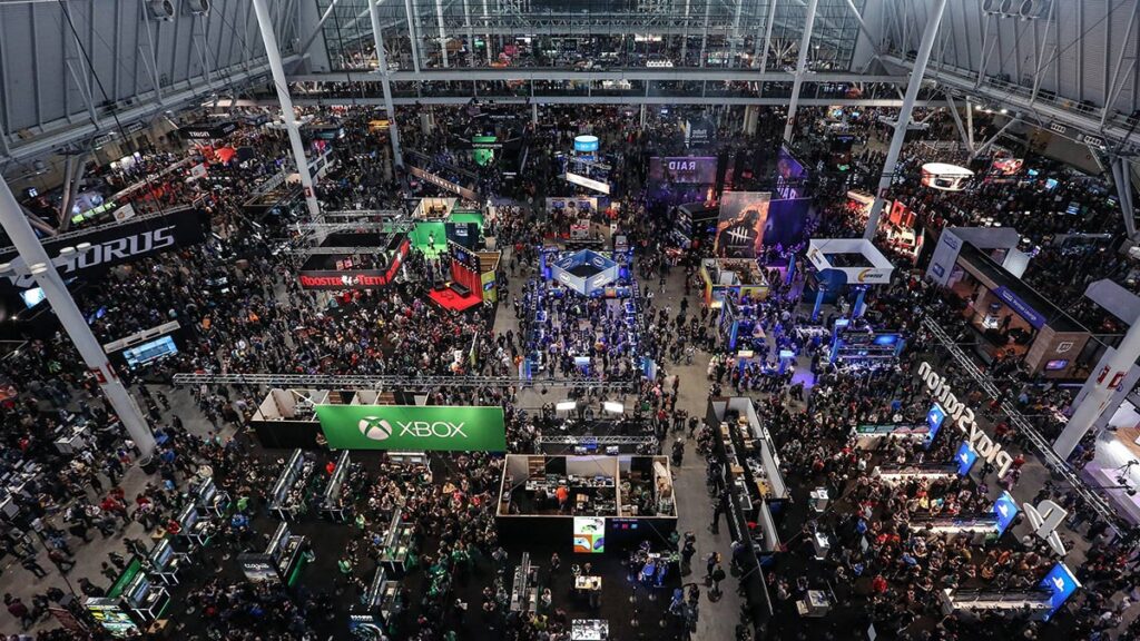 Wide view of the PAX East gaming expo showcasing bustling booths, including Xbox, PlayStation, and gaming enthusiasts exploring the event.